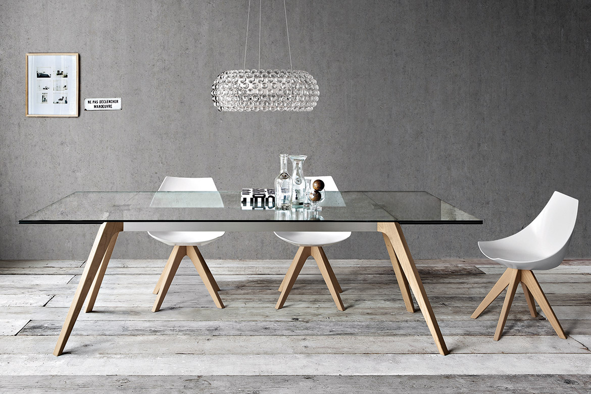 tavolo delta con piano in vetro allungabile e gambe in legno, sedia gamma con seduta in poliamide bianco con razze in legno pianca
