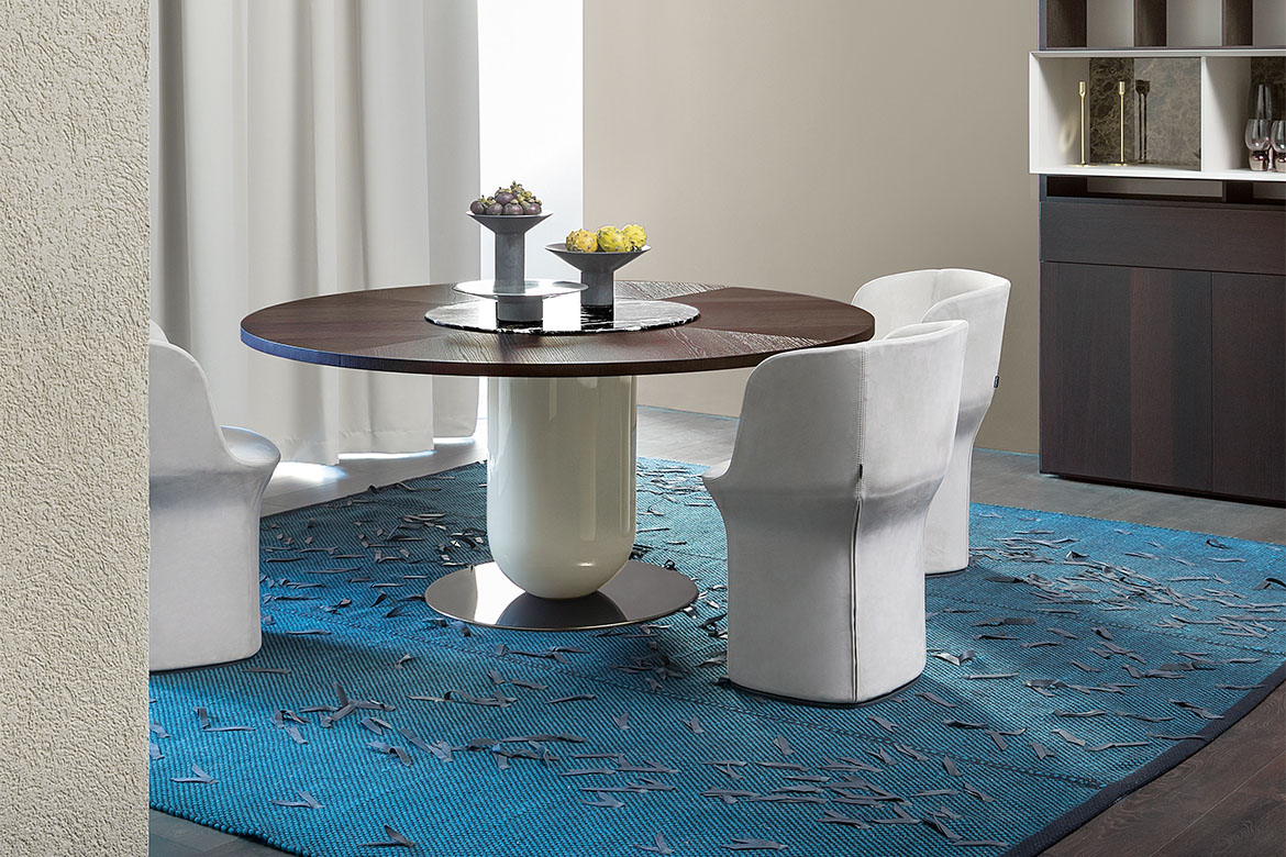 tavolo ettore rotondo con piano lazy susy girevole in marmo emperador design Calvi Brambilla, poltroncine in pelle con basamento girevole design Philippe Tabet per Pianca, tappeto ulisse con inserti in pelle tessoria asolana