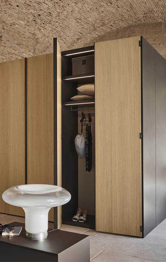 Armadio Amalfi Pianca in legno certificato FSC®, con ante aperte e illuminazione interna in un ambiente contemporaneo.