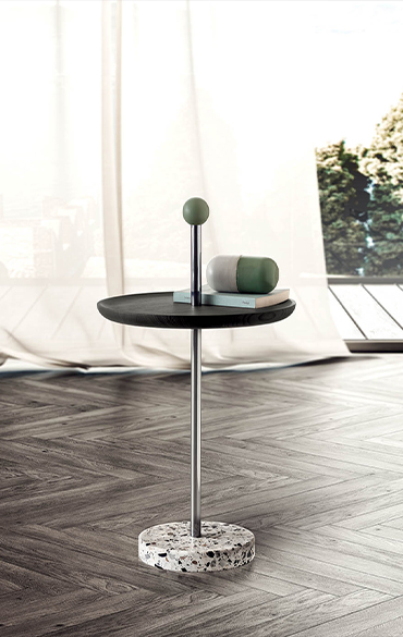 Tavolino Contralto Pianca in legno certificato FSC®, con piano scuro e base decorativa in un interno contemporaneo.